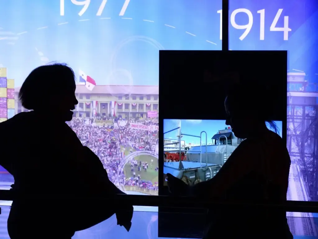 Siluetas de visitantes frente a una exposición del Centro de Visitantes de Miraflores